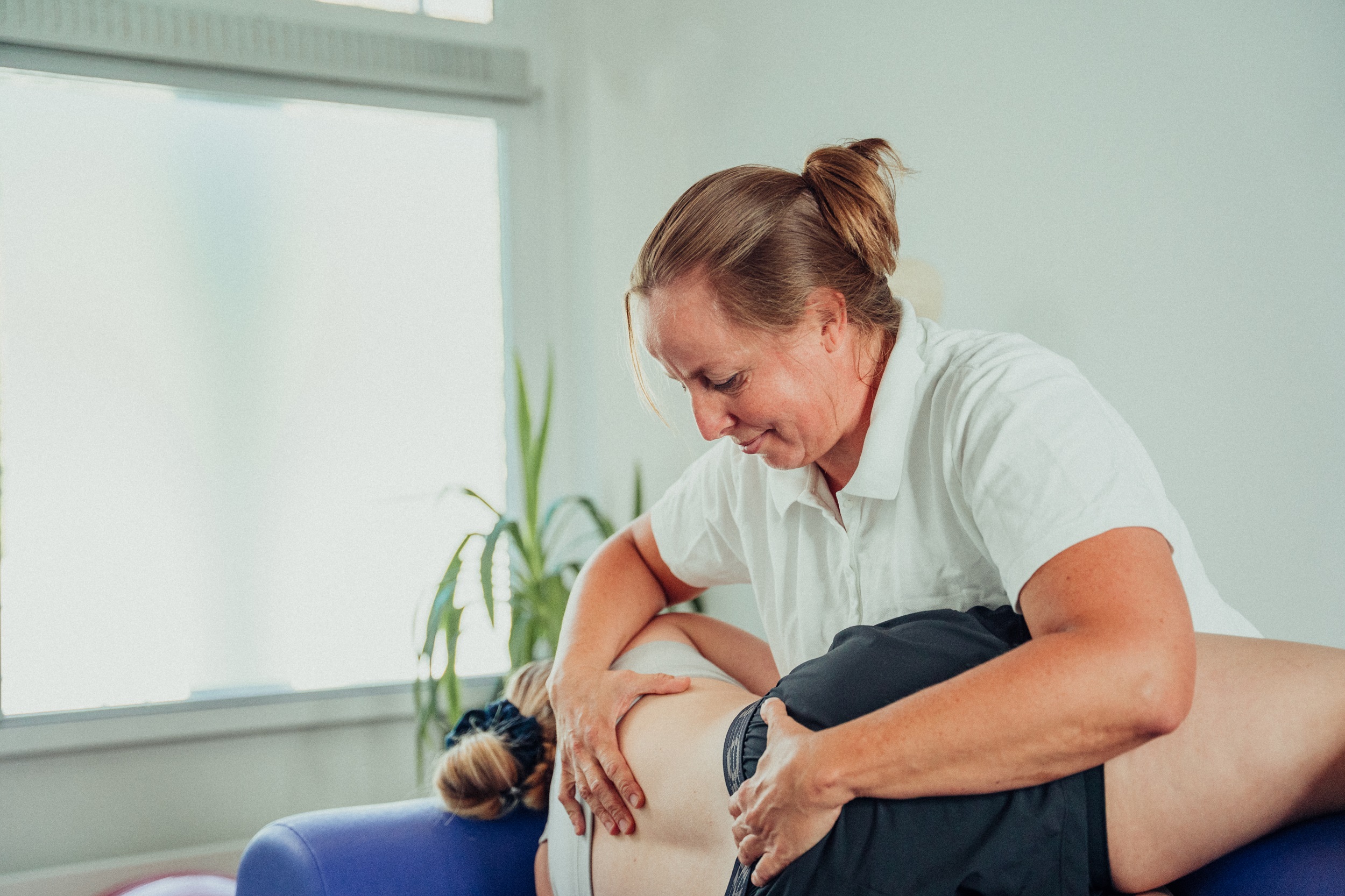 Physiotherapeutin behandelt Patientin auf der Liege 