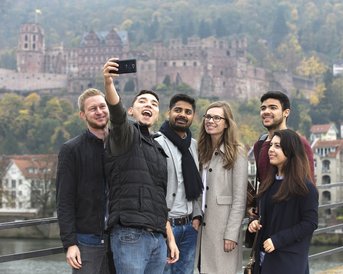 Internationale Studierende machen ein Selfie auf der alten Brücke