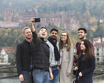 Internationale Studierende machen ein Selfie auf der alten Brücke