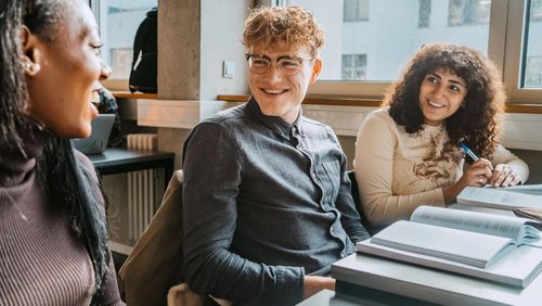 Drei Studienkollegen sind im Gespräch im Klassenraum der SRH University.