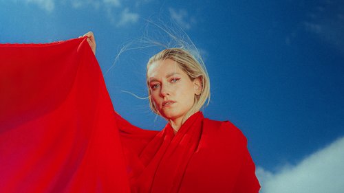 Frau im roten Kleid vor blauem Hintergrund