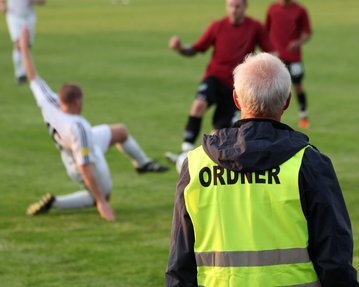 Ordner am Rande des Fußball-Felds