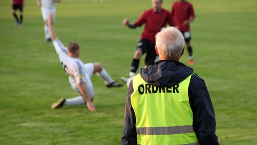 Ordner am Rande des Fußball-Felds