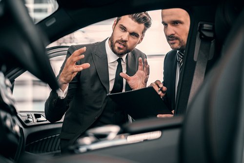 Zwei Businesspartner schauen sich ein Automobil an