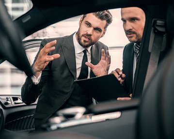 Zwei Businesspartner schauen sich ein Automobil an