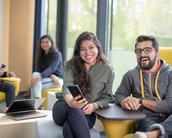 Zwei Studenten schauen lachend in die Kamera