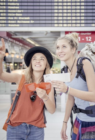 Zwei Studierende am Flughafen mit Gepaeck