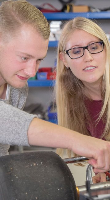 Studierende bauen an einer Automaschine.