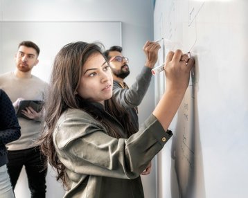 Studentin schreibt Prozess an ein Whiteboard